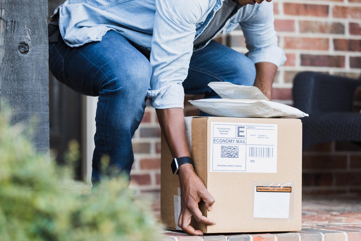 Man picking up packages on doorstep..