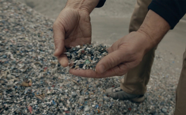 hands holding plastic pellets.